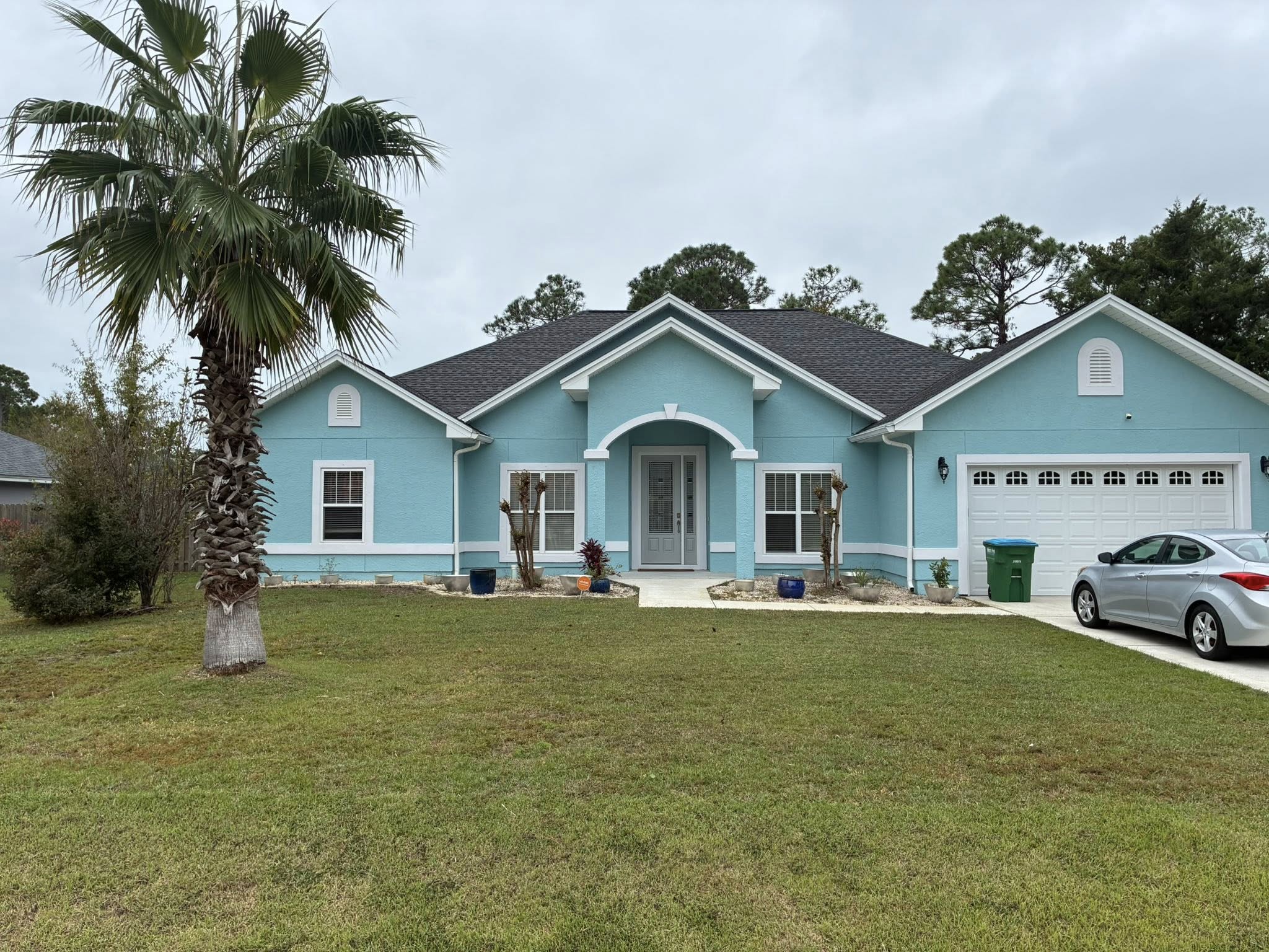 Exterior house painting — light blue stucco home in the Florida Panhandle by Harvey's Restoration