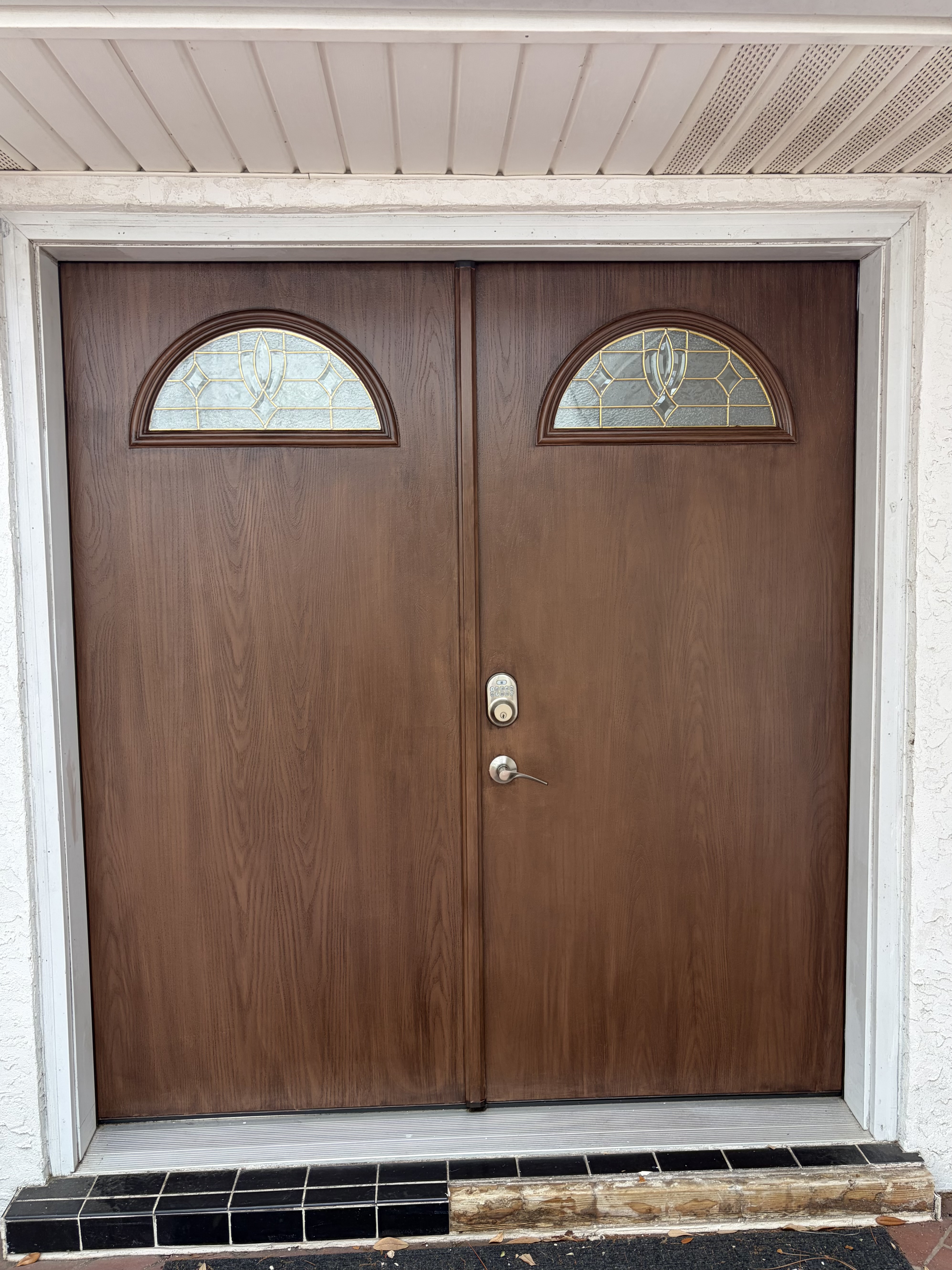 After — entry doors restored to natural wood finish by Harvey's Restoration